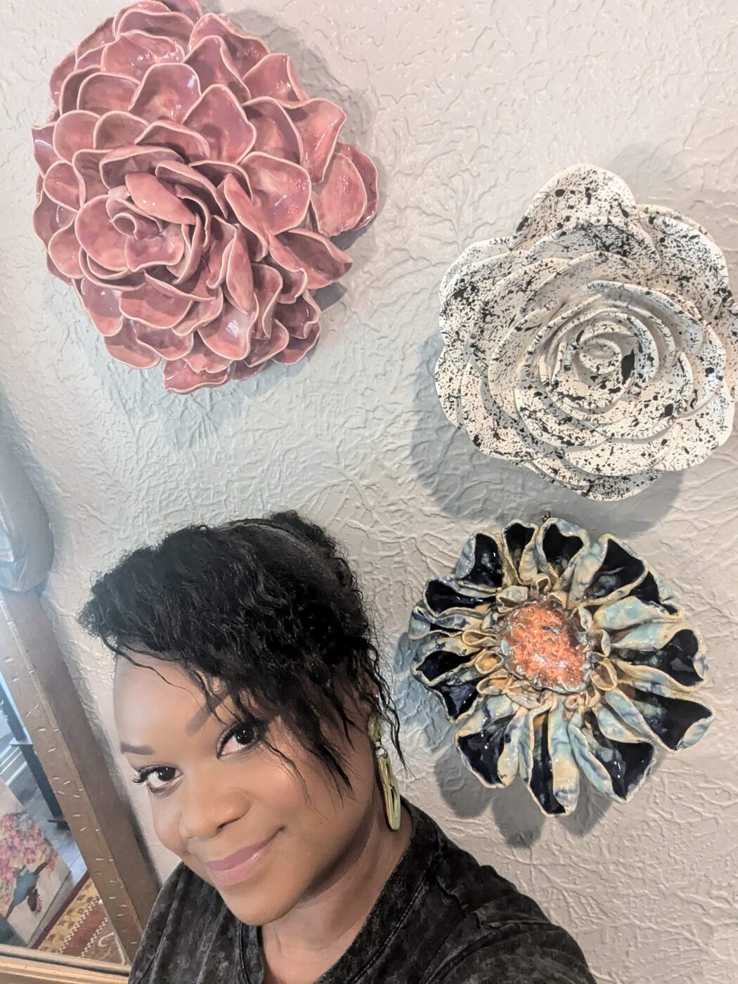 Jazmine with finished ceramic pieces on the wall