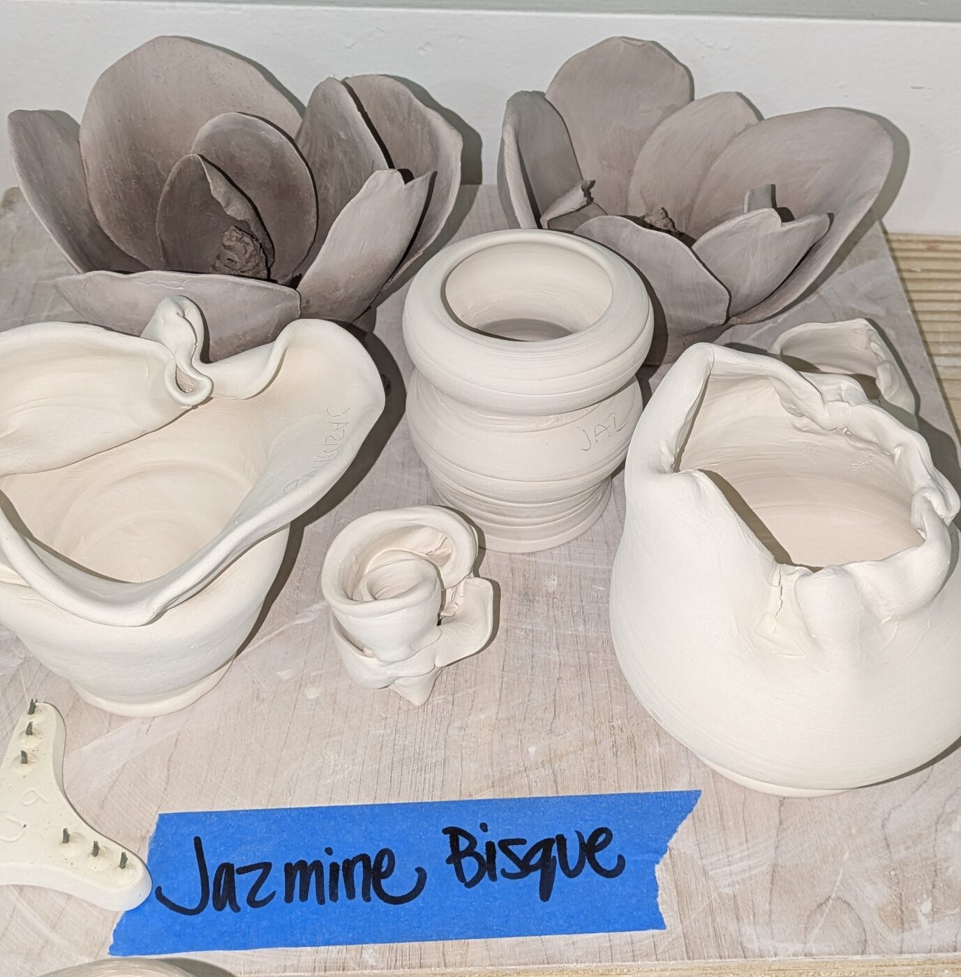 Bisque-fired pieces labeled and ready to glaze