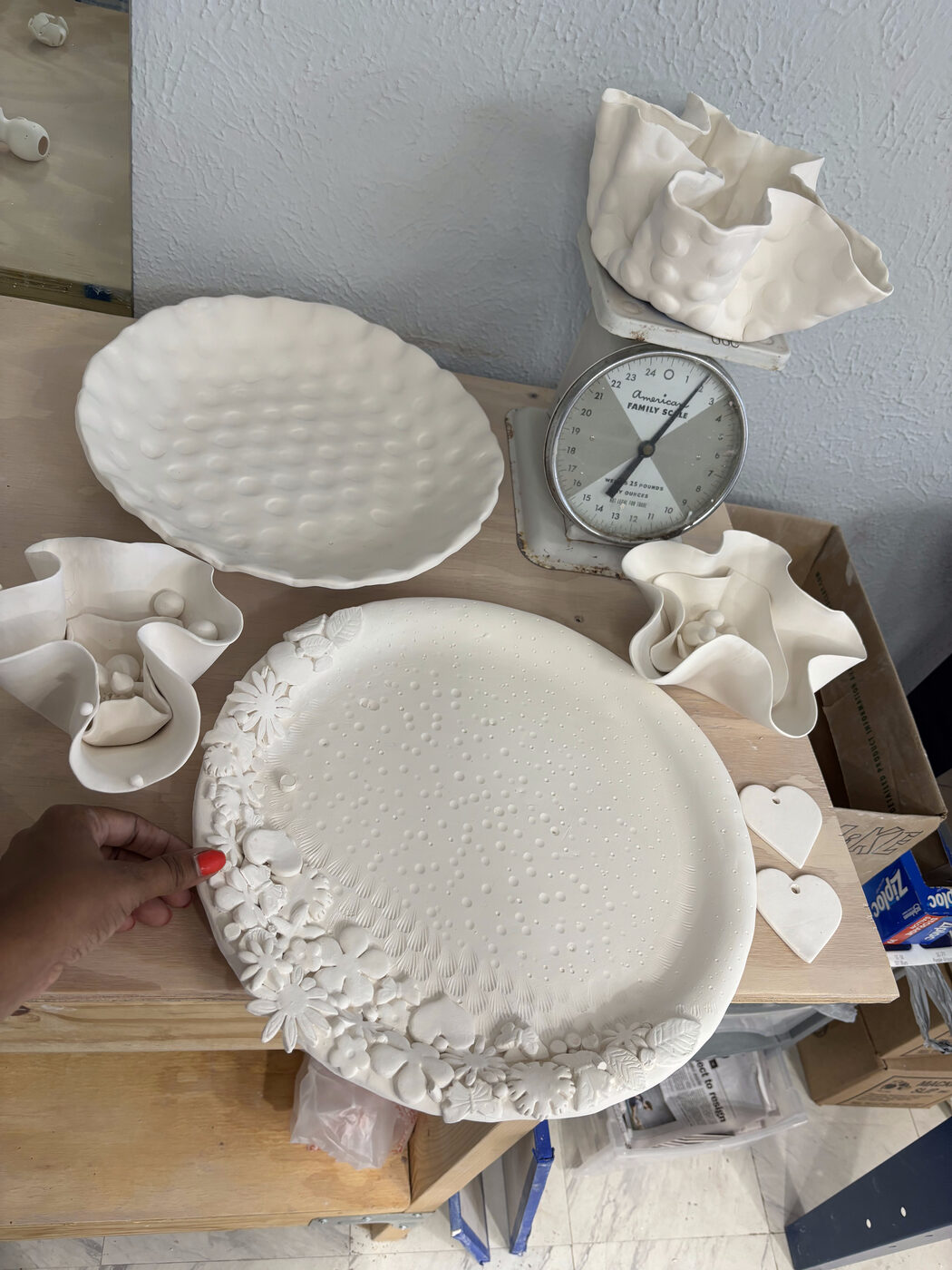 Bisque-fired plates and bowls on the worktable