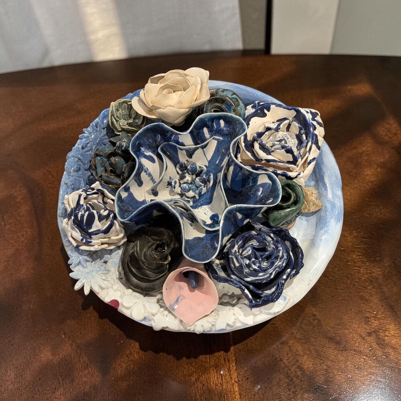 Handbuilt ceramic floral centerpiece arrangement on a plate