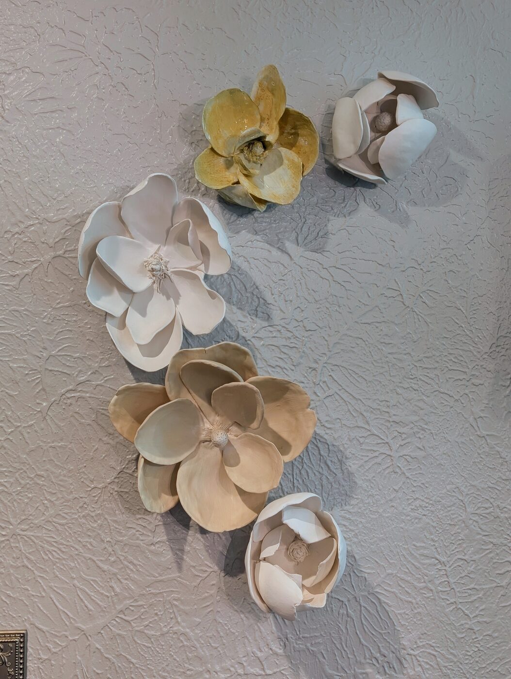 Handbuilt ceramic magnolia grouping on wall