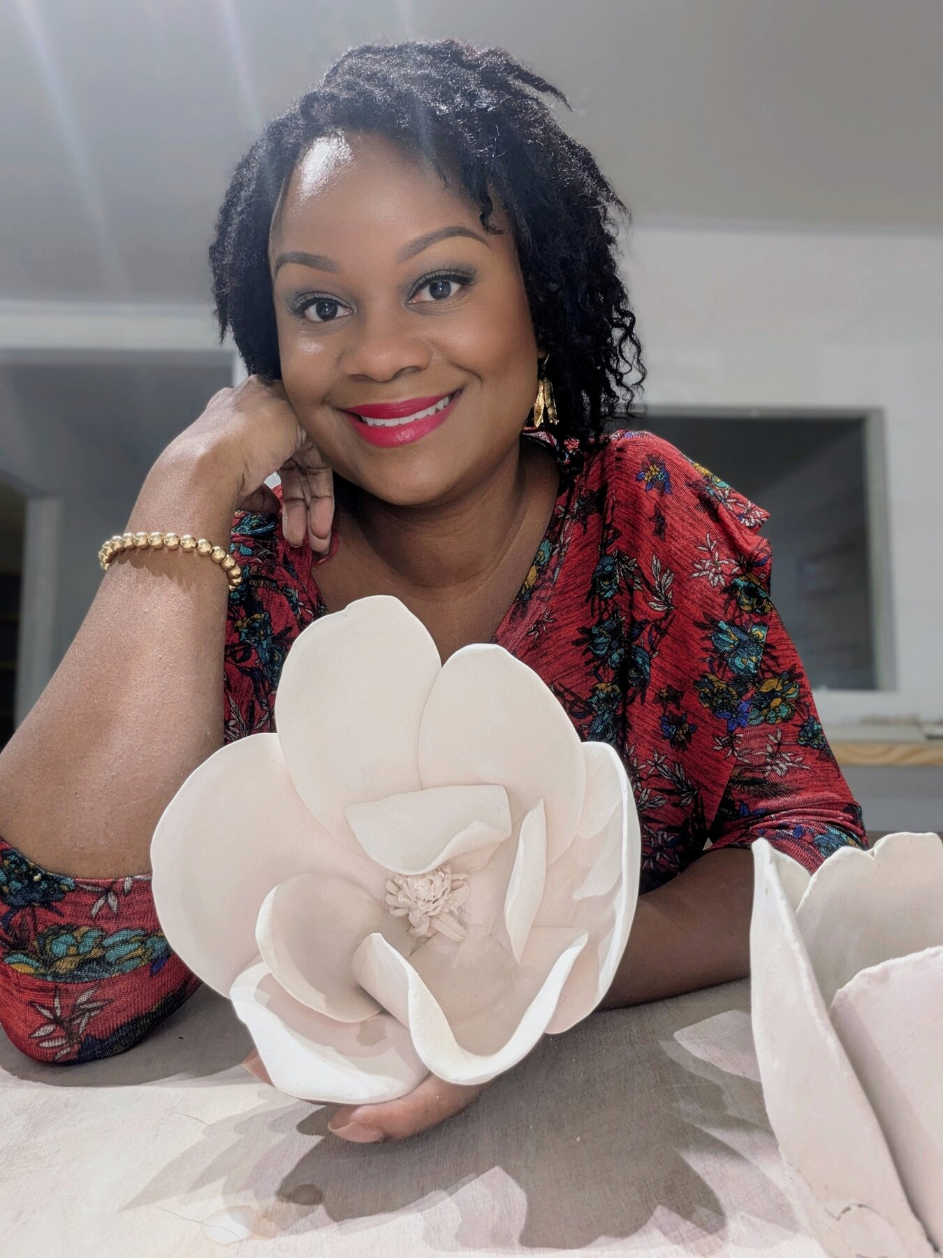 Jazmine Reynolds holding a handbuilt ceramic magnolia piece