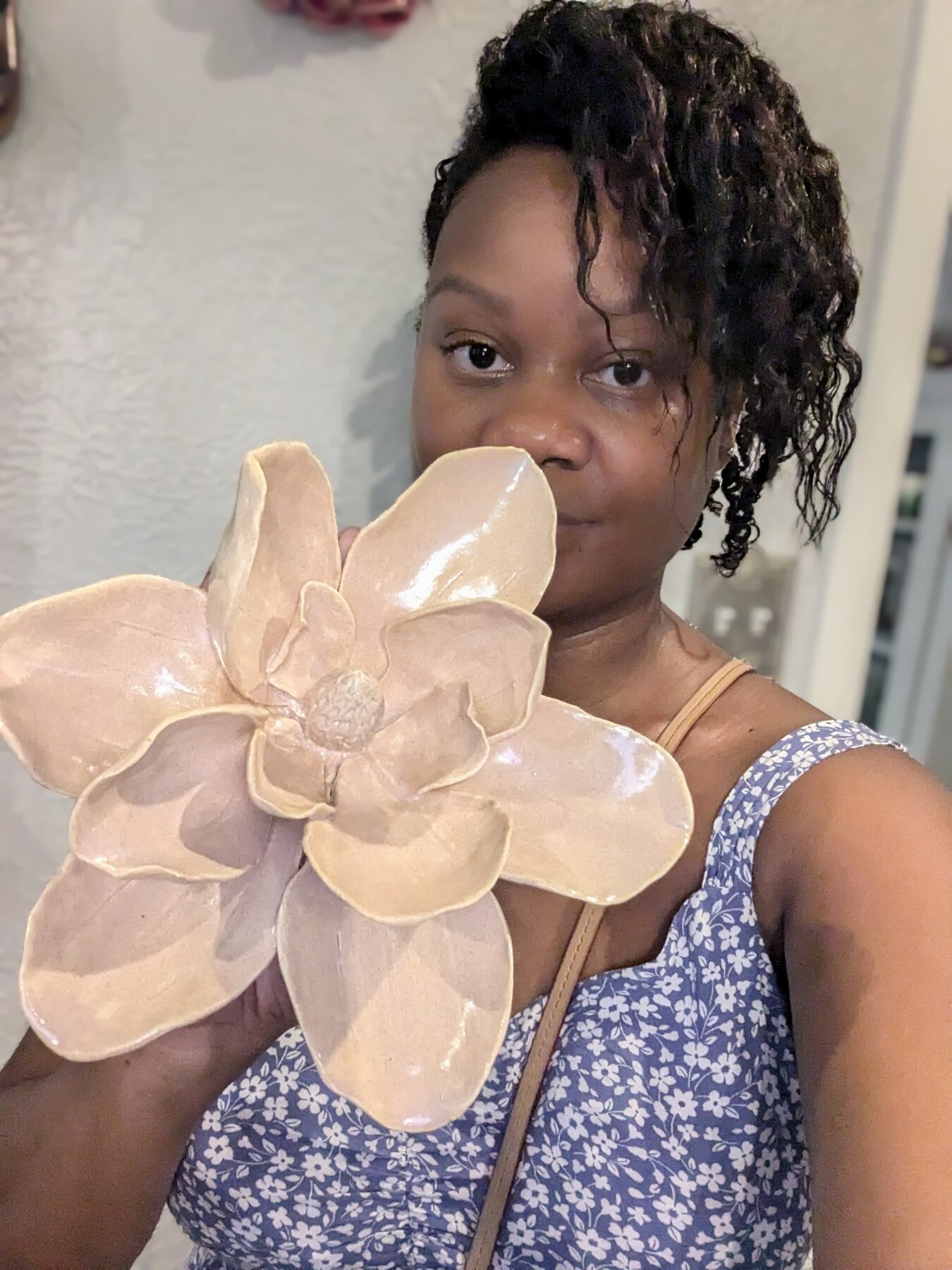 Jazmine Reynolds holding a handbuilt ceramic magnolia